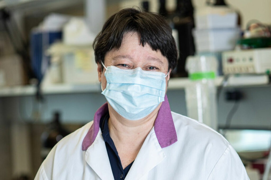 Dr. Katalin Szaszi, wearing a face mask, stands in her laboratory.