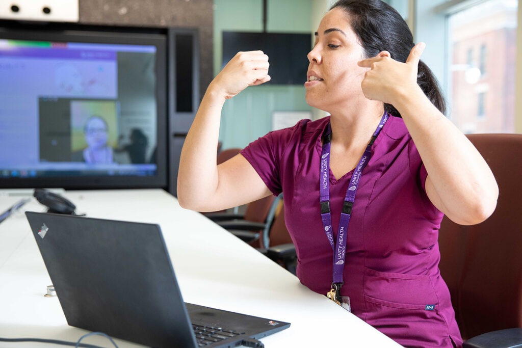 Camila Valente gestures to a webcam during a virtual breastfeeding course.