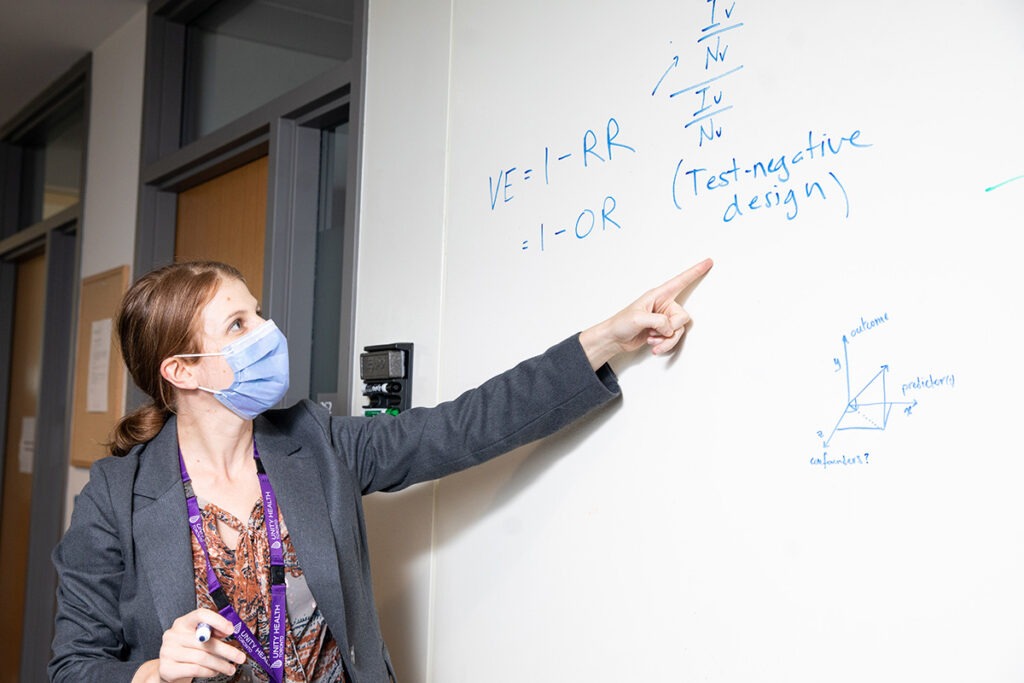 Dr. Korryn Bodner points to a formula on a whiteboard.