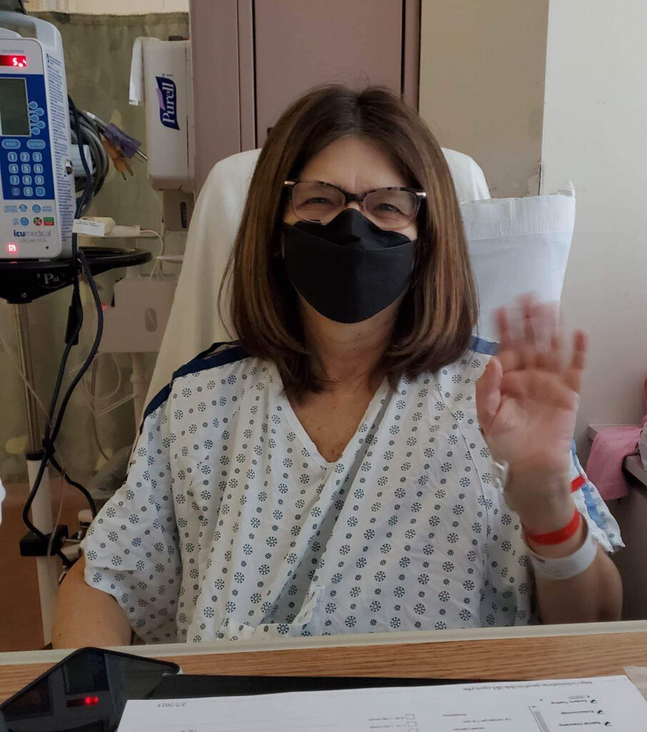 Laura Reid waves to the camera in her hospital bed after surgery.