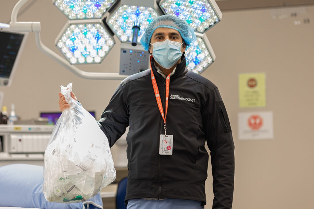 Dr. Ali Abbass holds a bag of collected used biomedical devices ready to be sent for reprocessing.