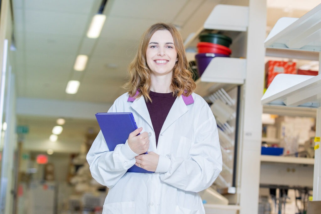 Dr. Veronique Miron, wearing a lab coat, stands in the Keenan Research Centre for Biomedical Science.